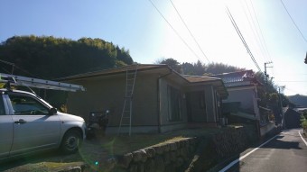 屋根に梯子をかけた写真